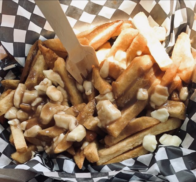Poutine. Traditional Meal Of Canada Made Up Of Chips Covered In Gravy With Cheese.