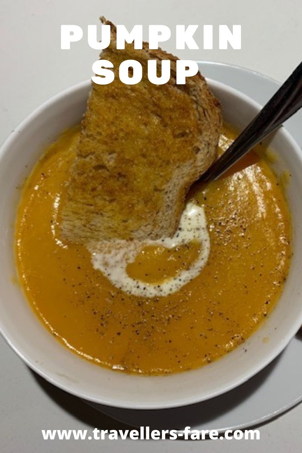 Pumpkin Soup In A White Bowl With A Dollop Of Cream And Black Pepper On Top. Served With Buttered Toast.