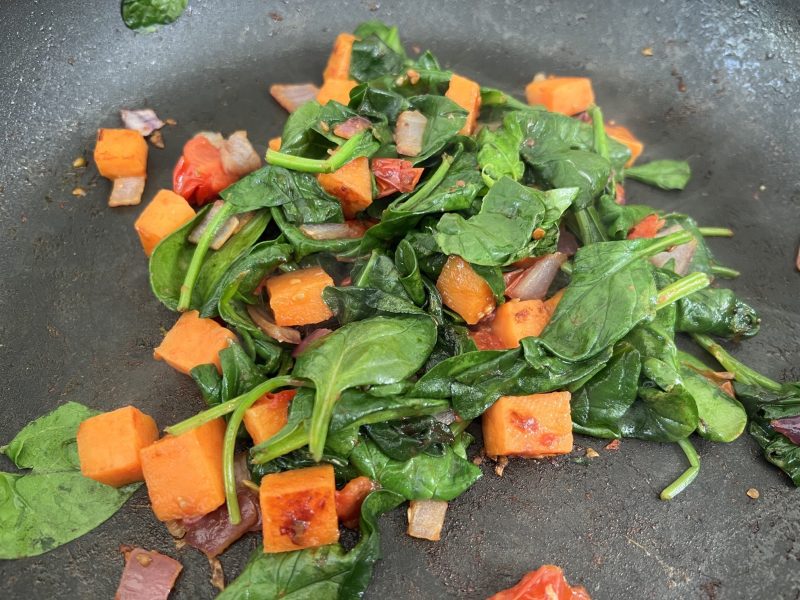 add spinach and cook down into onion, tomato and sweet potato mixture