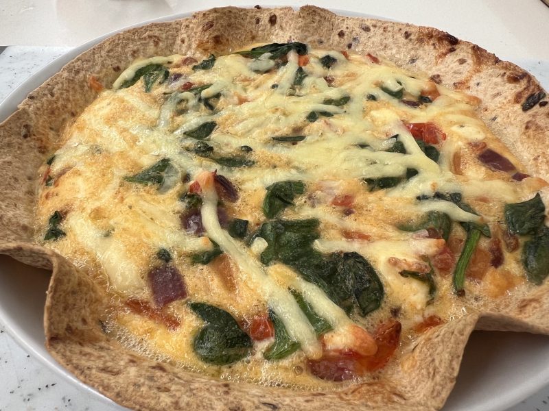 Savoury flan made of onion, tomato, sweet potato, feta, spinach and eggs